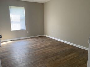 Richmond apartment for rent - A room with wooden flooring and a window with blinds.