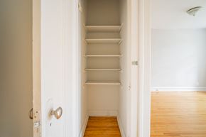 Chicago apartment for rent - a small closet in a room with wooden floors and empty shelves
