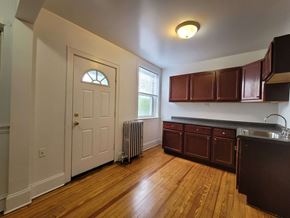 Chicago apartment for rent - an empty kitchen with wooden floors and a white door