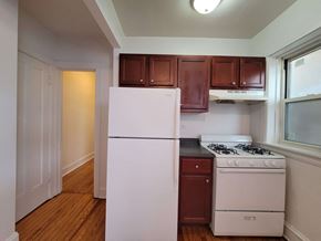 Chicago apartment for rent - a kitchen with white appliances and brown cabinets and a white refrigerator