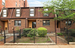 Washington apartment for rent - a brick apartment building with a yard and a wrought iron fence