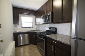 Evanston apartment for rent - a kitchen with dark wood cabinets and granite counter tops and stainless steel appliances