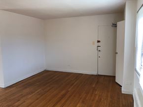 Evanston apartment for rent - a bedroom with white walls and a wooden floor and a closet