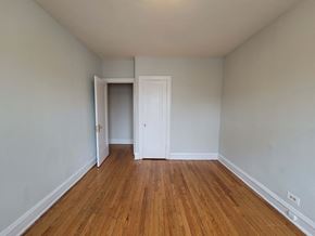 Chicago apartment for rent - a bedroom with wood flooring and white walls