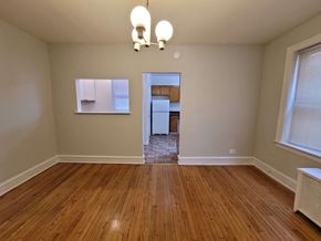 Chicago apartment for rent - a empty living room with wood floors and a kitchen