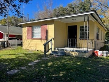 Jacksonville house for rent - a small yellow house with a porch and a fence