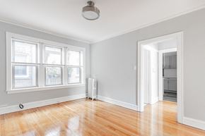 Chicago apartment for rent - an empty living room with a hard wood floor and white walls