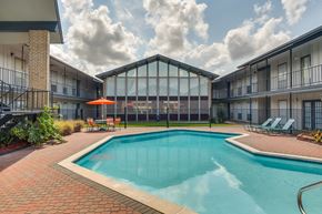 Lafayette apartment for rent - A swimming pool surrounded by a glass wall and a red umbrella.