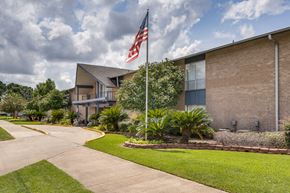 Lafayette apartment for rent - A building with a flag on a pole in front of it.