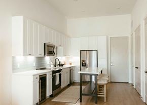 Dallas apartment for rent - a white kitchen with a table and a refrigerator