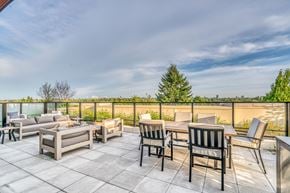 Vancouver apartment for rent - A patio with a table and chairs overlooking a fence.