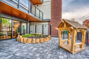 Vancouver apartment for rent - A wooden gazebo is situated in a courtyard with a circular garden bed.