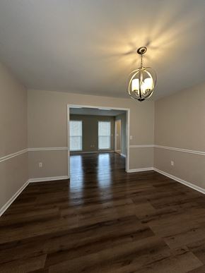 Clarksville house for rent - an empty living room with wooden floors and a chandelier