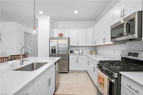 Estero house for rent - a white kitchen with stainless steel appliances and a sink