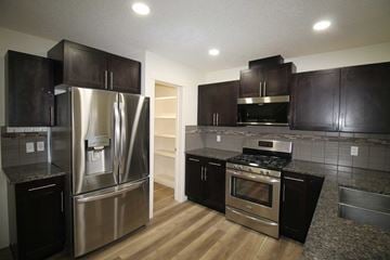 Edmonton house for rent - a kitchen with stainless steel appliances and black cabinets