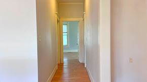 Bay City house for rent - a hallway with wood floors and white walls and a window