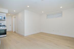 Vancouver apartment for rent - a kitchen and living room with white walls and wood flooring