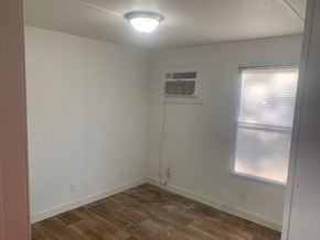 Greenwood house for rent - A room with a window and a wall-mounted air conditioner unit.