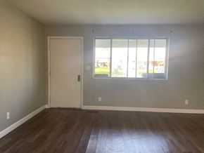 Lima house for rent - an empty living room with a window and wooden floors