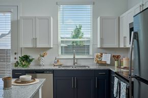 Leander apartment for rent - A kitchen with dark blue cabinets and a granite countertop.