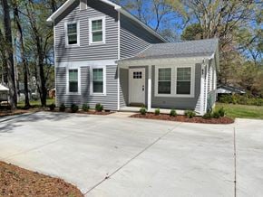 Angier house for rent - a white house with a large driveway in front of it