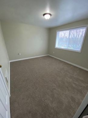 Seattle house for rent - an empty room with a window and a carpet