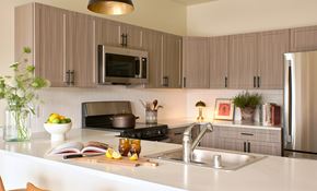 Missoula apartment for rent - A modern kitchen with a white countertop and a black stove.