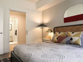 Oakland apartment for rent - A bedroom with a large bed and a lamp.