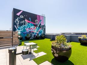 Oakland apartment for rent - A mural of a man with a guitar is painted on a building.