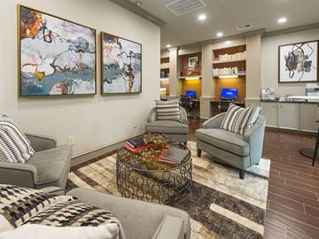 Houston apartment for rent - A living room with a grey couch, a coffee table, and two paintings on the wall.