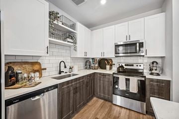 Denver apartment for rent - A modern kitchen with white cabinets and stainless steel appliances.
