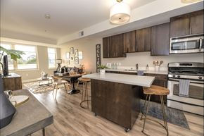 Mountain View apartment for rent - A modern kitchen with dark wood cabinets and a white island.
