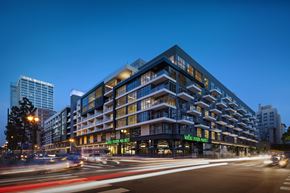 Los Angeles apartment for rent - A modern building with a green sign on the front.
