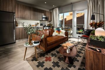 Los Angeles apartment for rent - A modern living room with a brown leather couch and a wooden coffee table.