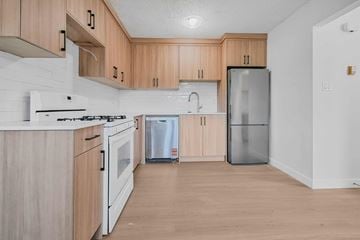 Calgary apartment for rent - A kitchen with wooden cabinets and white appliances.