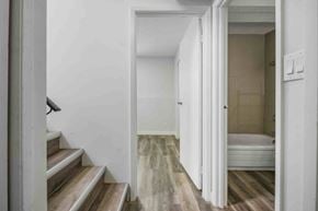 Calgary apartment for rent - A white room with a bed and a staircase.