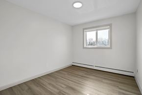 Calgary apartment for rent - A room with a window and wooden flooring.