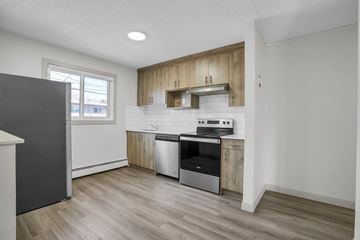 Calgary apartment for rent - A kitchen with a stainless steel oven and wooden cabinets.