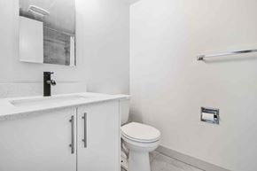 Calgary apartment for rent - A white toilet sits next to a sink in a bathroom.