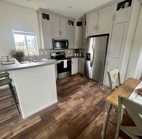 Flagstaff apartment for rent - a kitchen with white cabinets and a stainless steel refrigerator