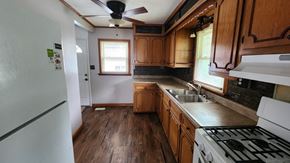 Cincinnati house for rent - a kitchen with wooden cabinets and a stove and a sink