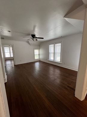 Waukegan apartment for rent - an empty living room with wood floors and a ceiling fan