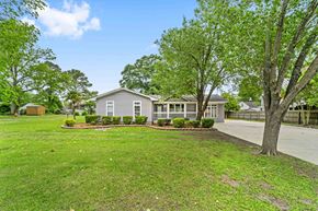 Richlands house for rent - a gray house with trees and grass in front of it
