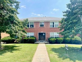 Louisville apartment for rent - a brick house with a lawn and trees in front of it