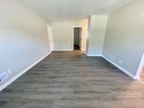 Louisville apartment for rent - a empty living room with wood flooring and white walls