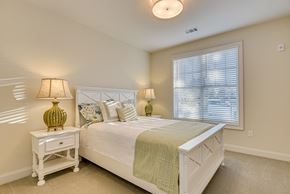Aiken apartment for rent - A bedroom with a bed, nightstand, and lamp.