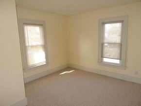 South Bend apartment for rent - A room with two windows and carpeted floor.