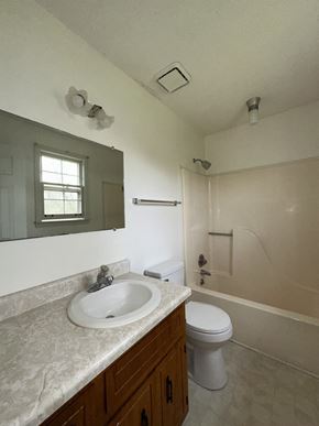 Clarksville house for rent - A bathroom with a sink, toilet, and bathtub.