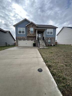 Clarksville house for rent - a blue house with a driveway and a garage door