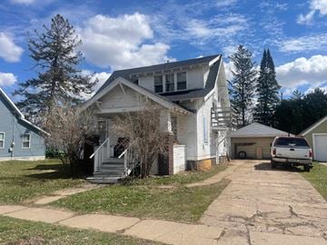 Menomonie house for rent - a white house with a van parked in front of it